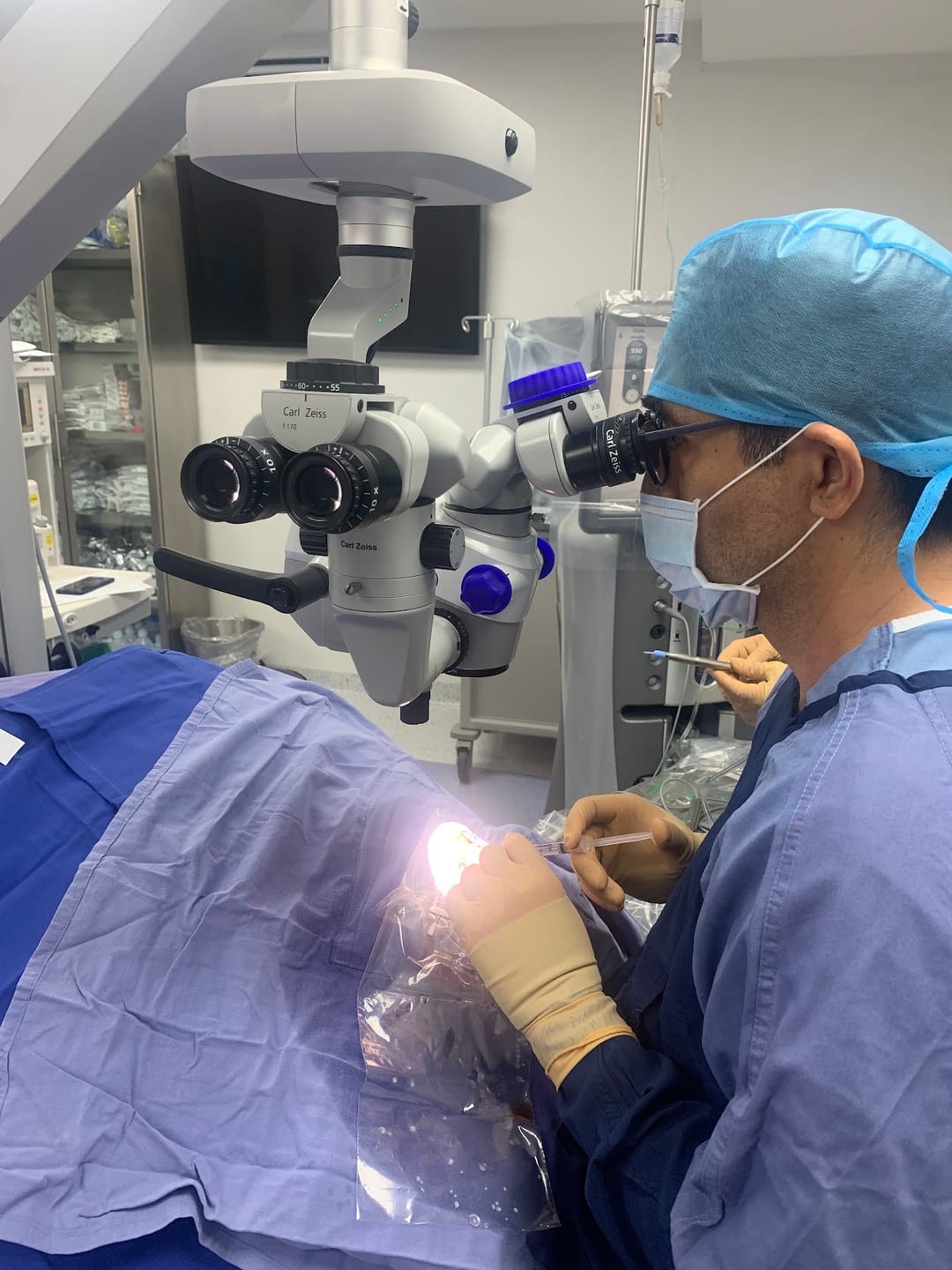 El doctor en quirófano, con microscopio quirúrgico